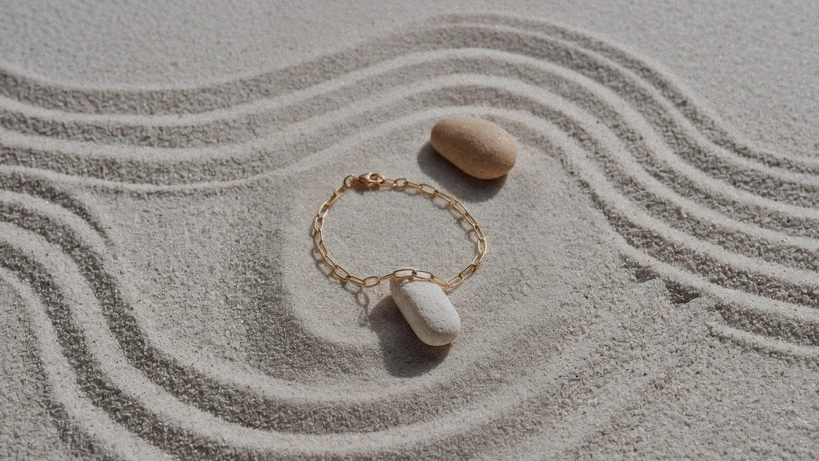 A Ygeia bracelet resting on raked sand